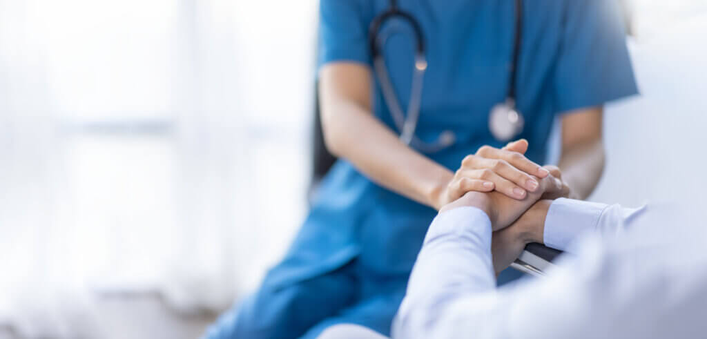 Female Nurse Holding Senior Patient's Hand