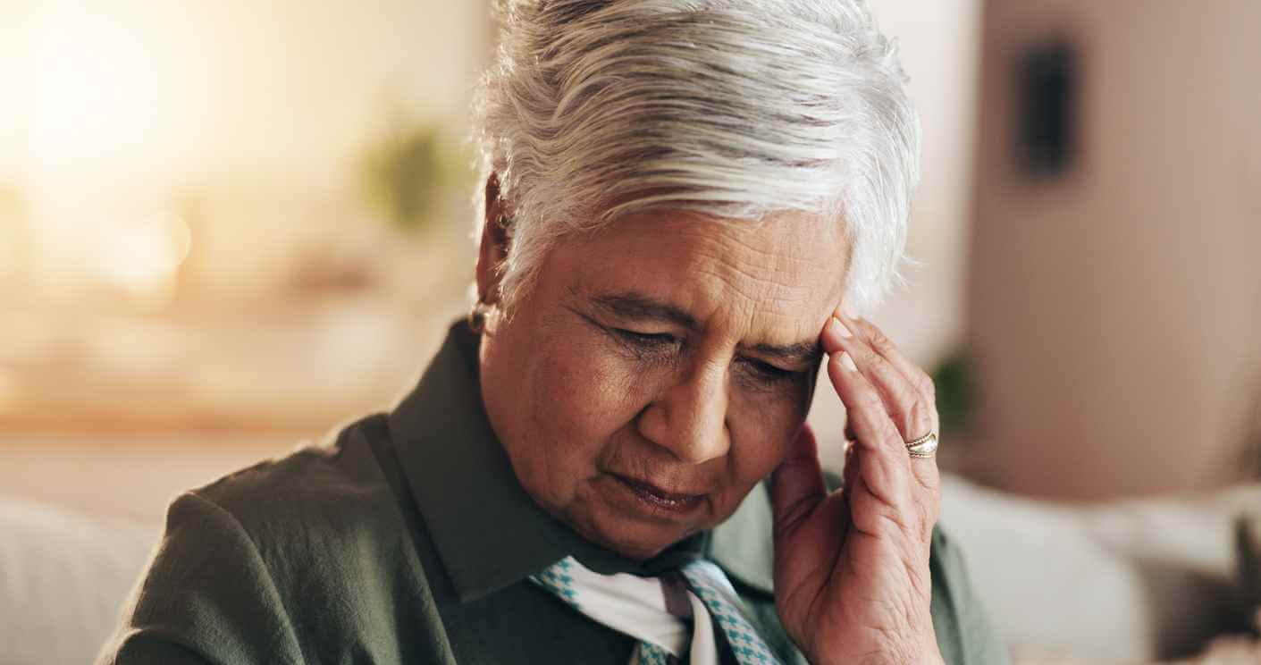 Older woman resting her hand on her forehead due to lack of memory